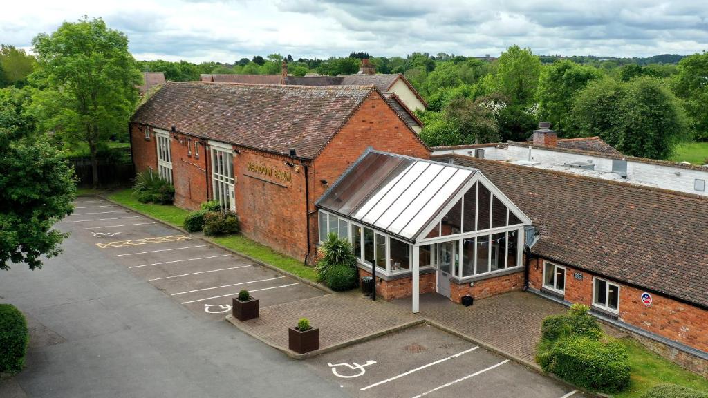 an overhead view of a large brick building with a greenhouse at Meadow Farm Redditch by Marstons Inns in Redditch