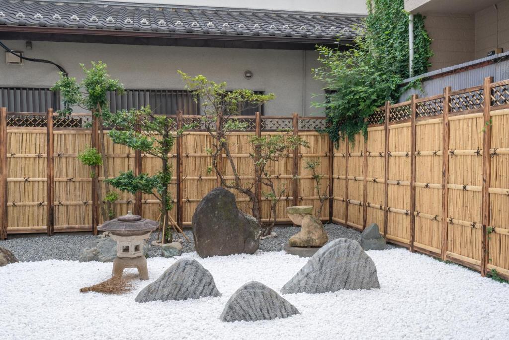 un jardin avec des rochers devant une clôture en bois dans l'établissement Otuska house with 2BR near the Yamanote line, à Tokyo