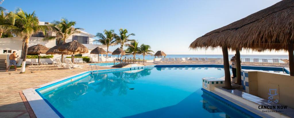 einen Pool mit Blick auf den Strand in der Unterkunft Brisas Beachfront Penthouses in Cancún