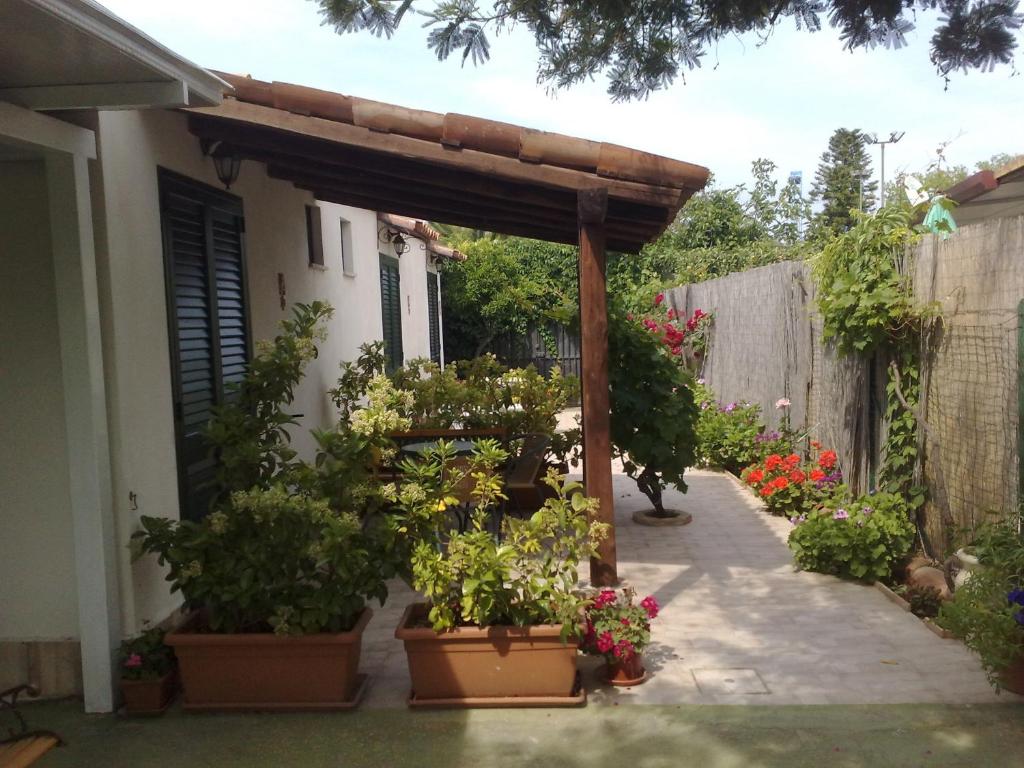 eine Pergola mit Topfpflanzen auf einer Terrasse in der Unterkunft Villa Verdemare Naxos in Giardini-Naxos