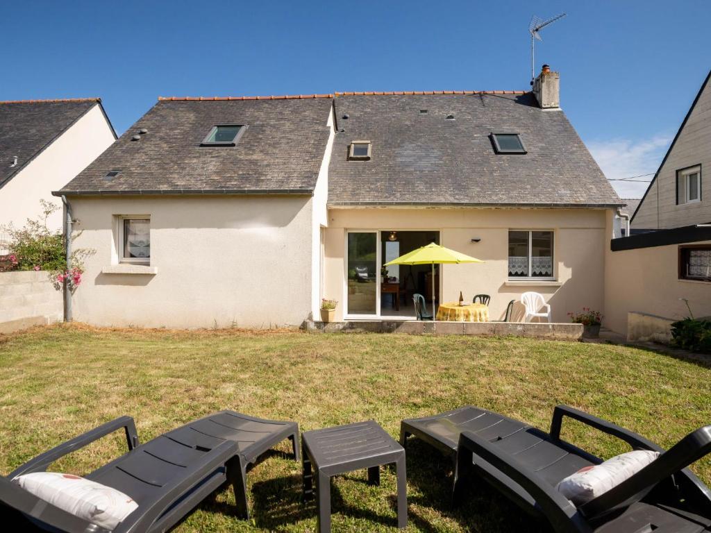 a house with two picnic tables in the yard at Holiday Home l'Emeraude by Interhome in Matignon