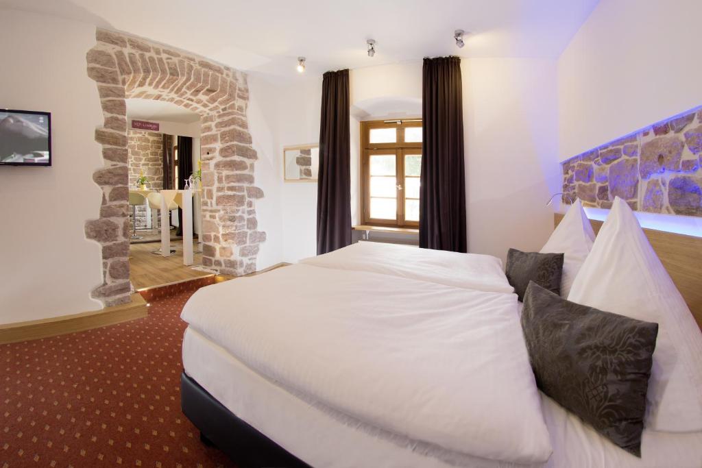 ein Schlafzimmer mit einem großen weißen Bett in einem Zimmer in der Unterkunft Hotel Landgasthof König von Preussen in Marxzell