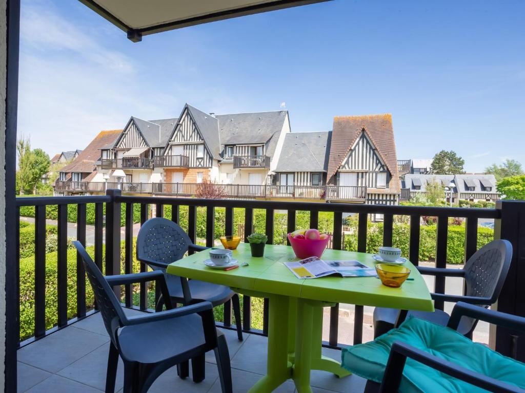 d'une table et de chaises vertes sur un balcon dans l'établissement Apartment Fleur Marine-30 by Interhome, à Cabourg