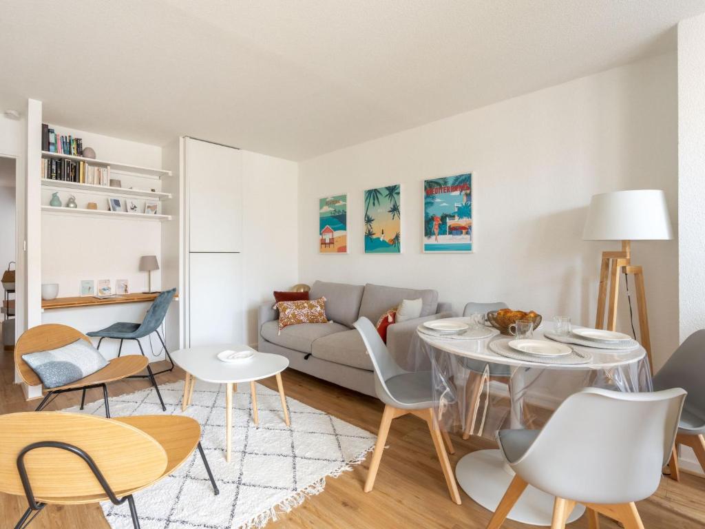 uma sala de estar com um sofá, uma mesa e cadeiras em Apartment Les Hélianthes-2 by Interhome em Lacanau-Océan