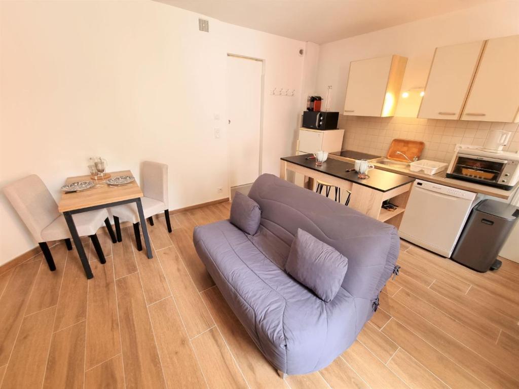 un salon avec un canapé et une table dans une cuisine dans l'établissement Apartment Les Figuiers by Interhome, à Dinard