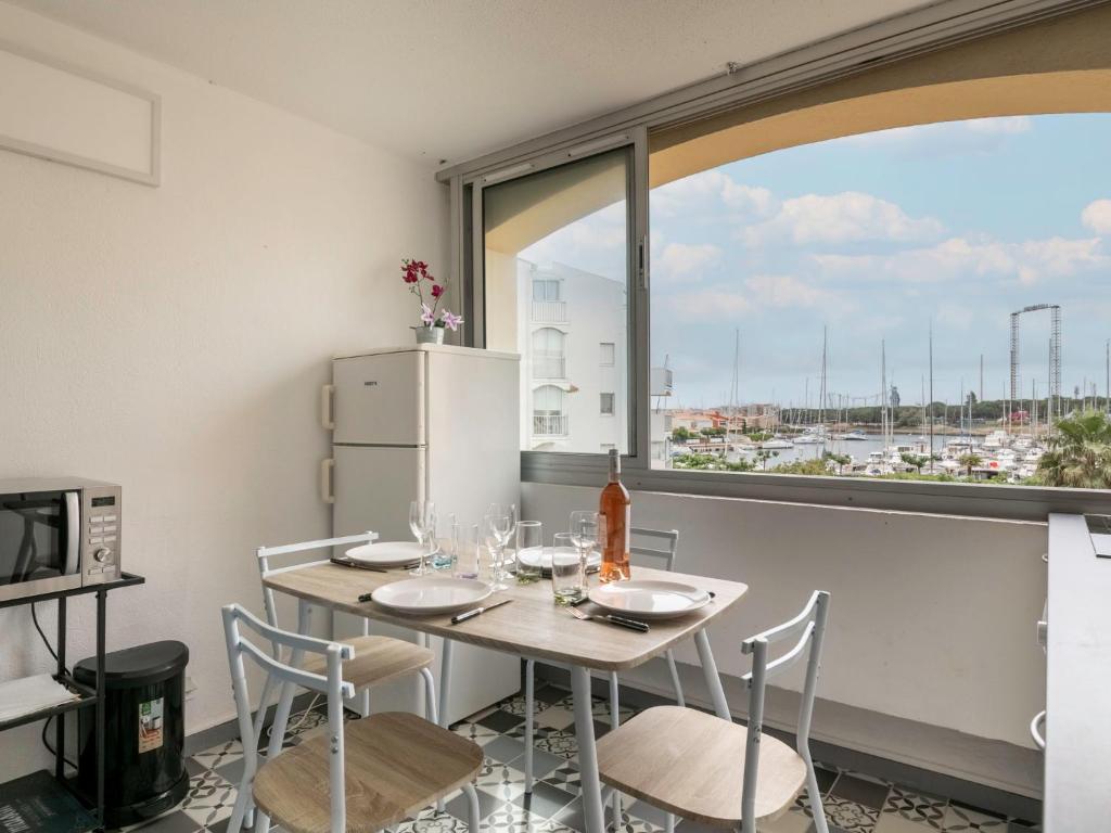 a kitchen with a table and chairs and a window at Apartment Les Héliades-2 by Interhome in Cap d'Agde