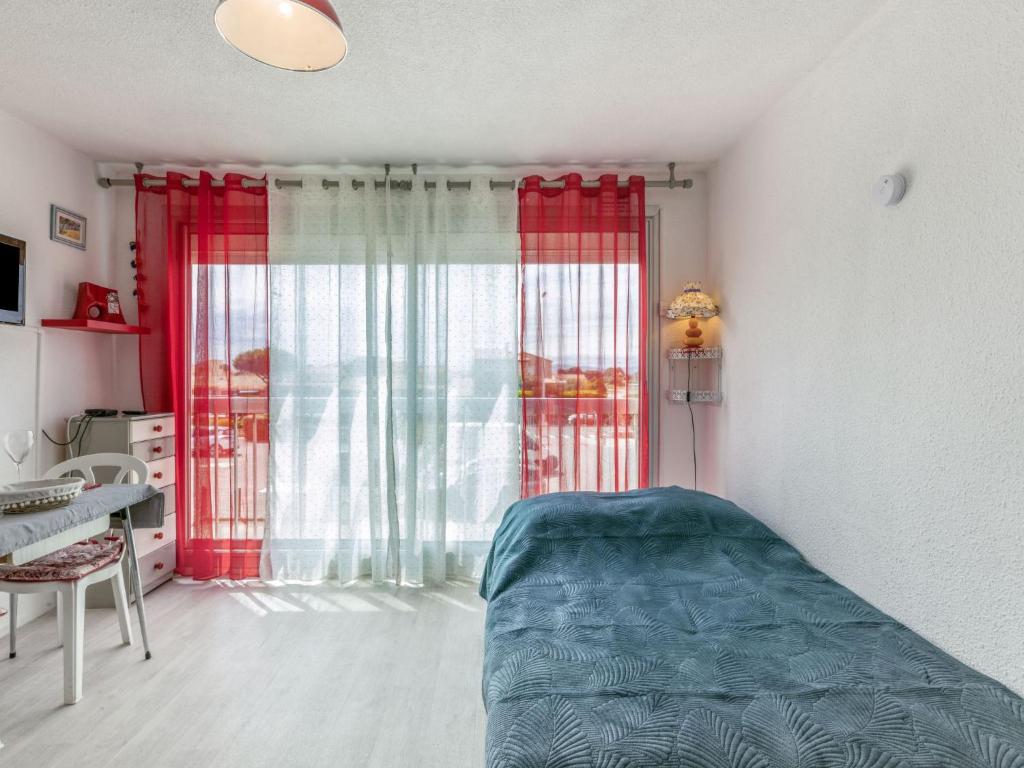 sypialnia z łóżkiem i czerwoną zasłoną w obiekcie Apartment Port Plage 2 by Interhome w mieście Le Barcarès