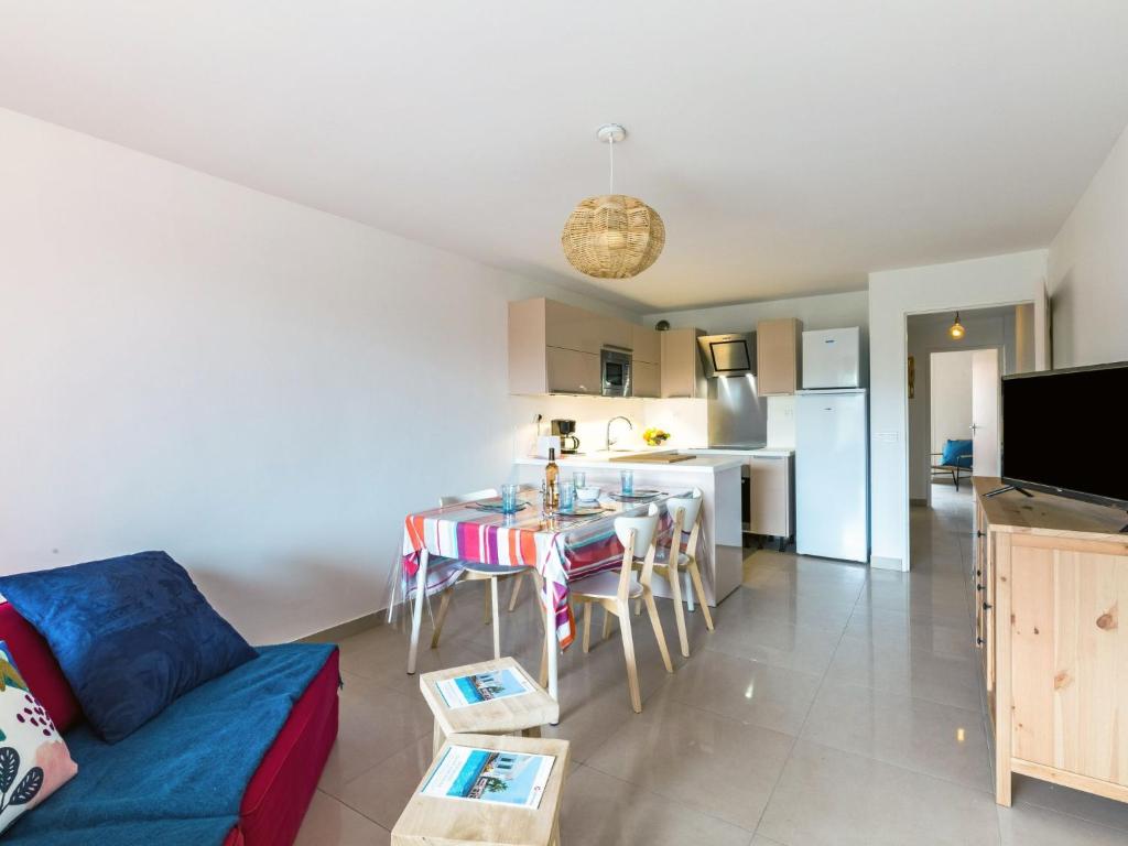 un salon avec un canapé bleu et une cuisine dans l'établissement Apartment La Chênaie-5 by Interhome, à Saint-Aygulf