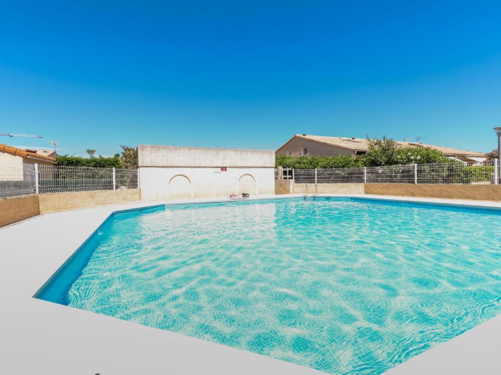 a large swimming pool with blue water at Holiday Home Les mas Bleus by Interhome in Saint Cyprien Plage