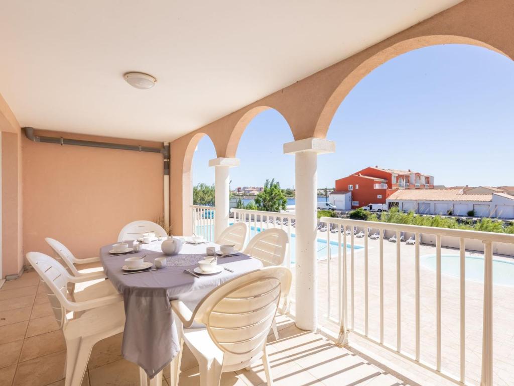 een eetkamer met een tafel en stoelen op een balkon bij Apartment Catalana by Interhome in Le Barcarès