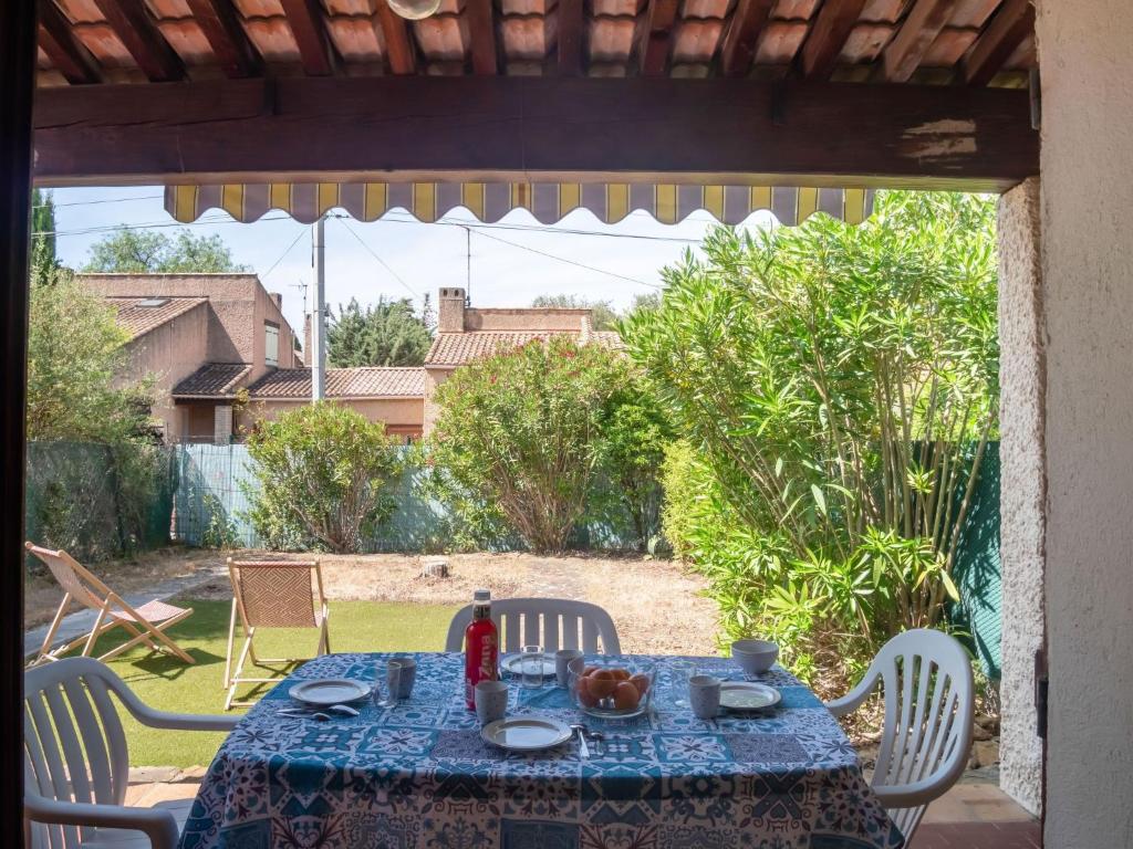 stół z niebieskim obrusem na tarasie w obiekcie Holiday Home Provence Parc-7 by Interhome w mieście Saint-Cyr-sur-Mer