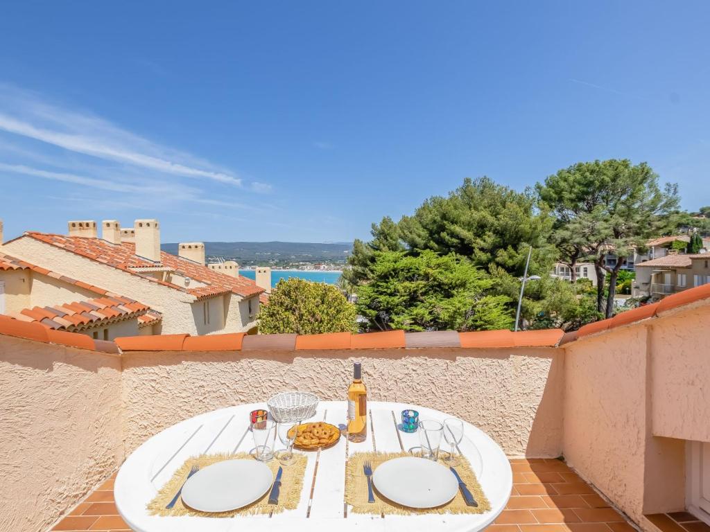 una mesa blanca con comida y bebidas en el balcón en Studio Château de la Madrague-8 by Interhome, en Saint-Cyr-sur-Mer