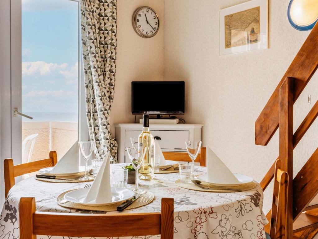 ein Esszimmer mit einem Tisch mit Stühlen und einem TV in der Unterkunft Apartment Les Roches Bleues-7 by Interhome in Collioure