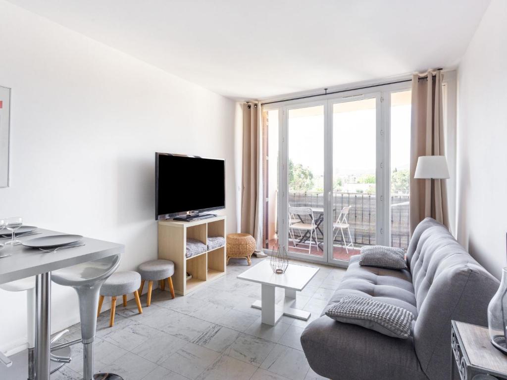 sala de estar con sofá y TV en Apartment Le Cormoran by Interhome, en Le Lavandou