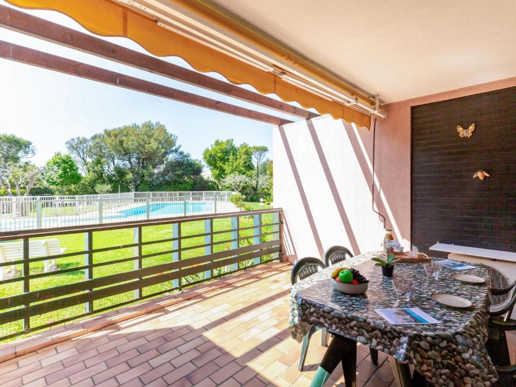 un patio avec une table et des chaises sur un balcon dans l'établissement Apartment Les Caroubiers-2 by Interhome, à Saint-Aygulf