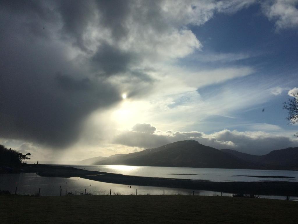 um pôr-do-sol sobre um corpo de água com montanhas em Kirkton Bay House Bed and Breakfast em Kyle of Lochalsh