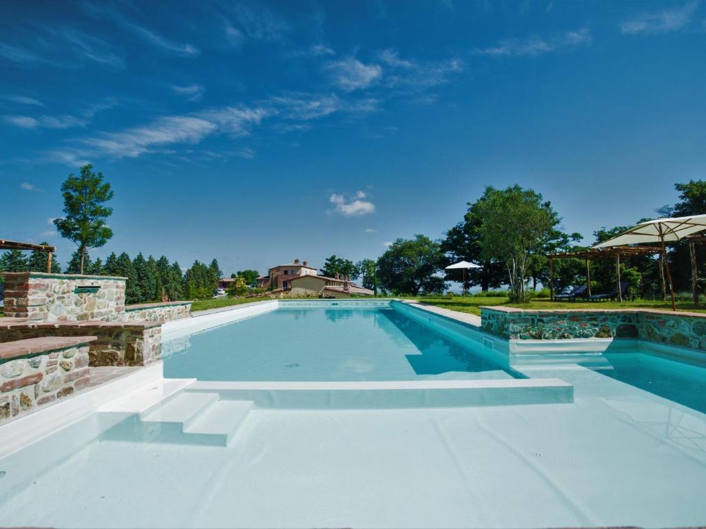 a large swimming pool with a clear blue sky at Holiday Home Villa Rosmarino by Interhome in Petroio