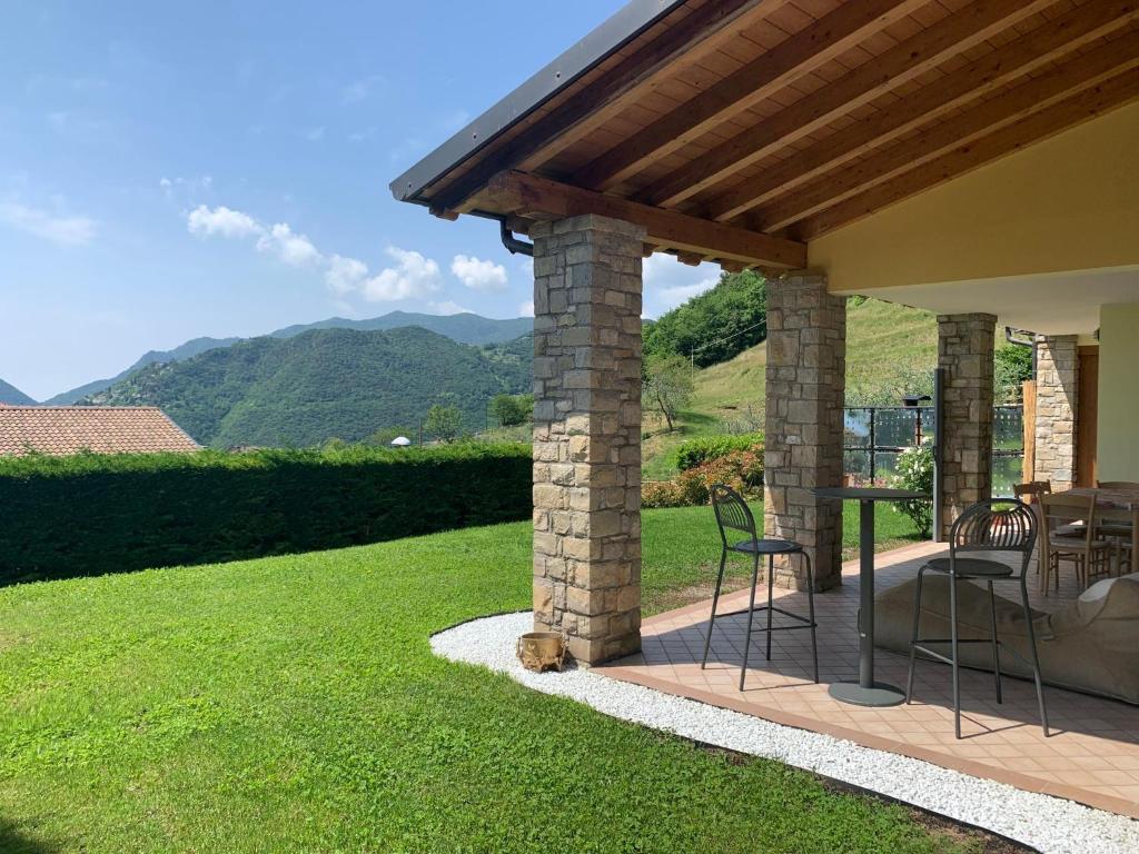 a patio with a table and chairs on a lawn at Holiday Home Aaron by Interhome in Tremosine Sul Garda
