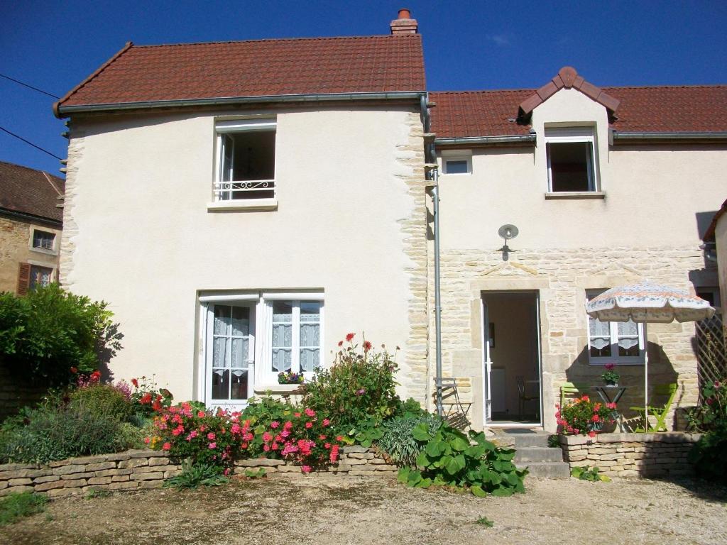 une maison blanche avec des fleurs devant elle dans l'établissement Holiday home Gîte des Hautes Côtes de Beaune, à Magny-lès-Villers