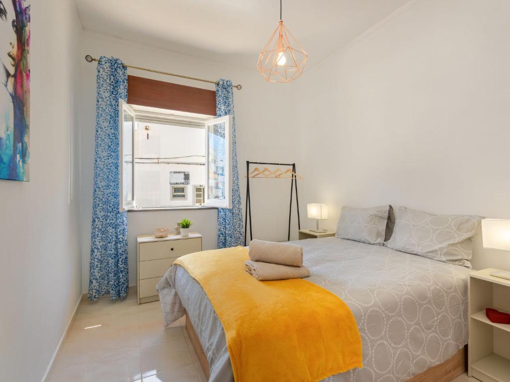 een slaapkamer met een groot bed en een raam bij Holiday Home Magnolia by Interhome in Olhão