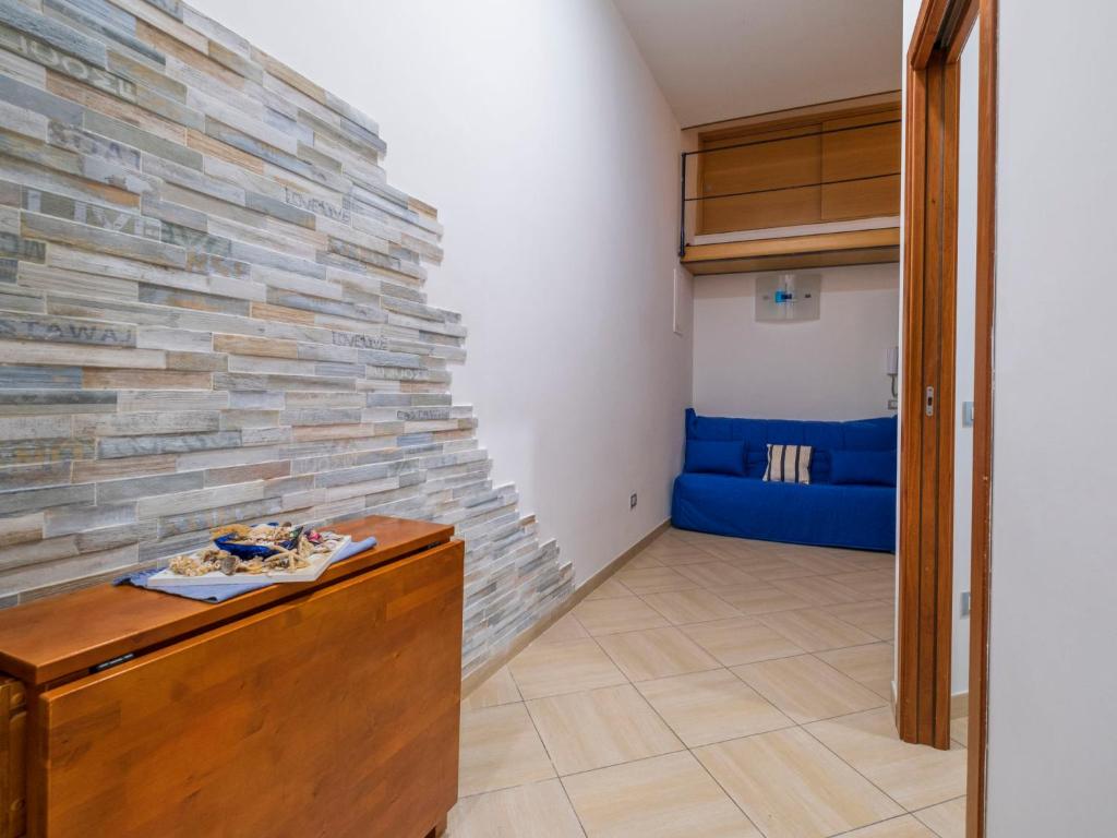 Pokój z kamienną ścianą i niebieską kanapą w obiekcie Apartment Sorrento Shore-Casa Mirta by Interhome w Sorrento