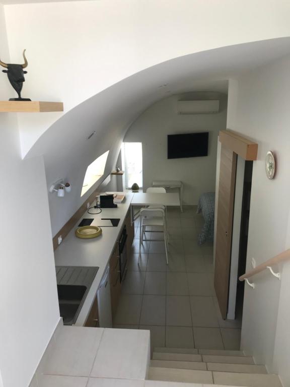 Ma maisonnette في ألّاوش: مطبخ مع درج يؤدي إلى غرفة المعيشة