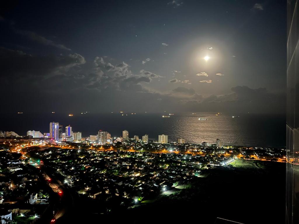 una vista de una ciudad por la noche con la luna en Umhlanga Arch Luxury, en Durban