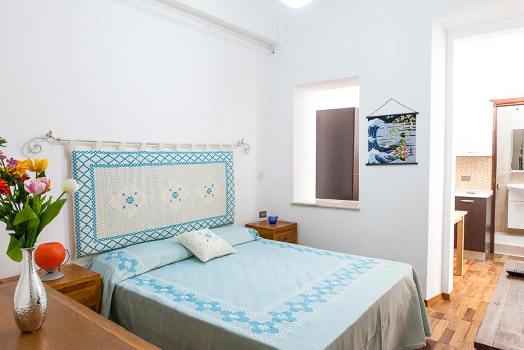 1 dormitorio con 1 cama y un jarrón de flores en Santa Restituta in Cagliari Centre Q4825, en Cagliari