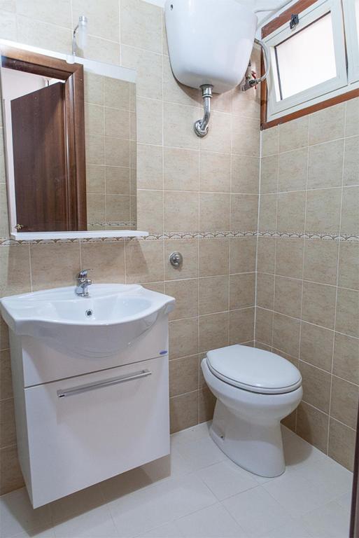 łazienka z umywalką, toaletą i lustrem w obiekcie Santa Restituta in Cagliari Centre Q4825 w Cagliari