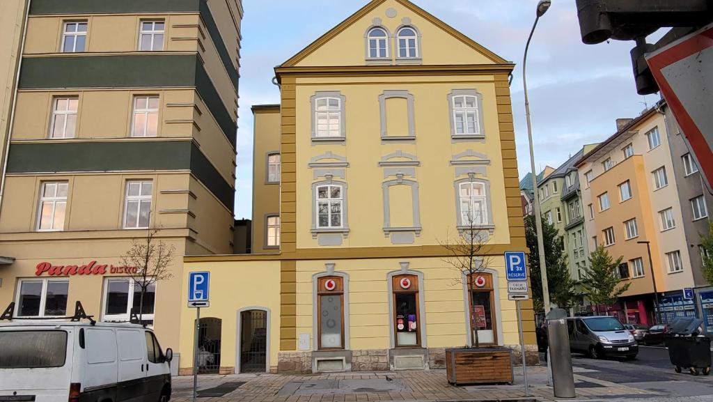 un bâtiment jaune avec une tour d'horloge dans une rue dans l'établissement K-HAUS, à Děčín