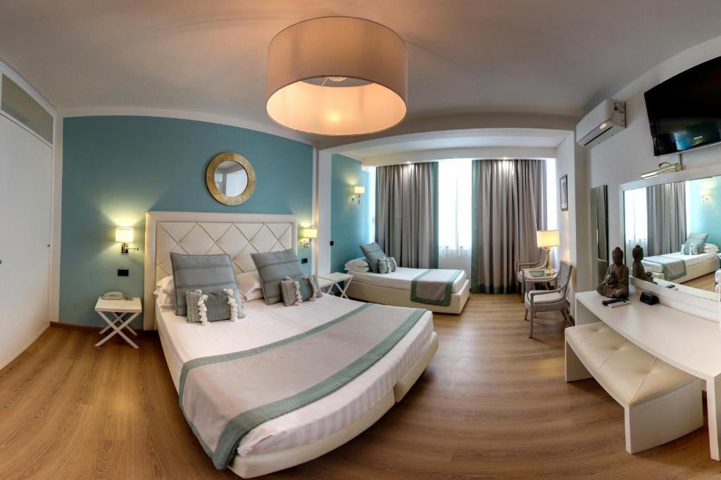 a hotel room with a large bed and a bathroom at Raffaelli Park Hotel in Forte dei Marmi