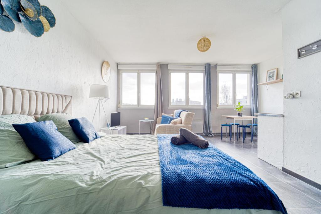 une chambre avec un grand lit avec des oreillers bleus dans l'établissement Mon Rez-de-Chaussée Ville Parking Privé Un-Séjour-à-Part, à Metz