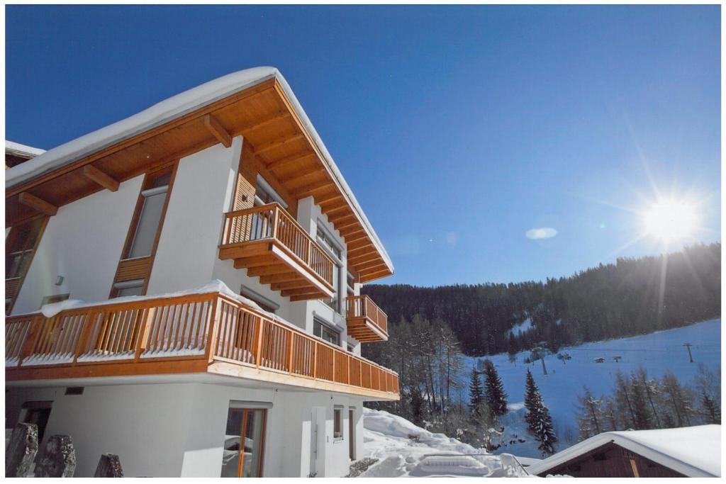 un edificio con balcón en lo alto de una ladera cubierta de nieve en Ferienwohnung Rust, en Fendels