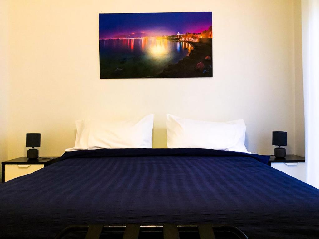 1 dormitorio con 1 cama con una pintura en la pared en B&B MaryJosè, en Trapani