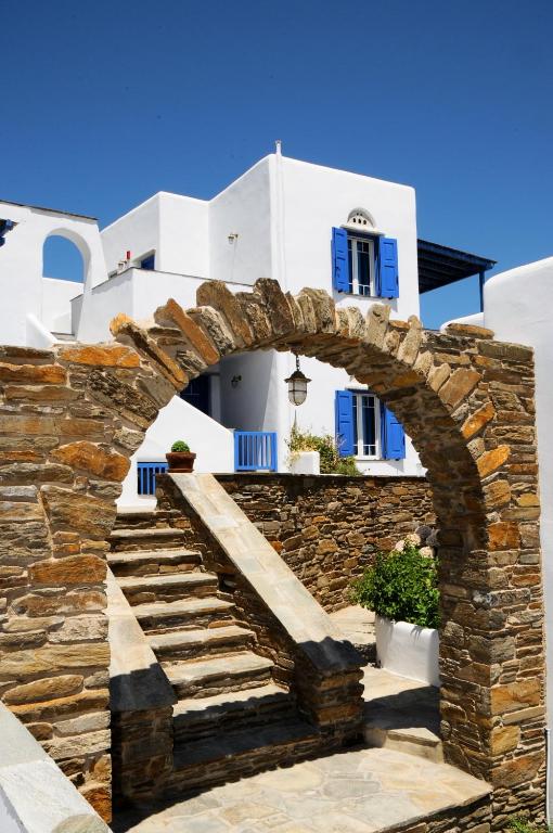 an archway with stairs in front of a white building at Karyatides Homes in Kariá