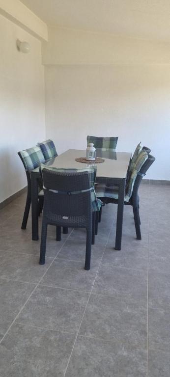 stół jadalny i krzesła z filiżanką kawy w obiekcie Apartments Anđa near Queen Beach w mieście Privlaka