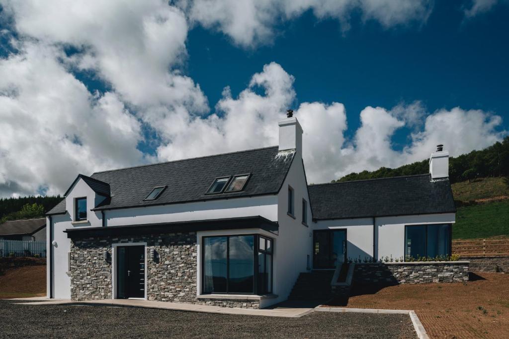 a white house with a stone facade at Lamb Cottage in Ballycastle