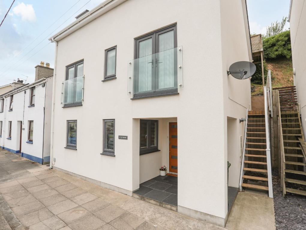 a house with white walls and windows at 3 Ty Stabal in Pwllheli