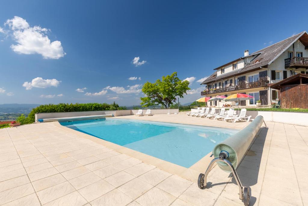 a swimming pool with chairs and a building at Appartement Mont Colombier in Trévignin