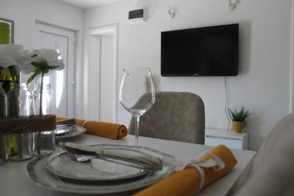 a dining room table with a wine glass on it at Apartment River in Klis