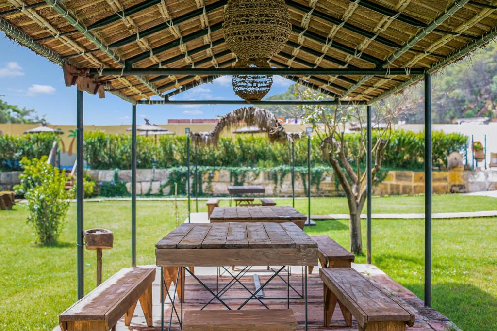 a picnic table with benches under a pavilion in a park at Casa de 10 - 1 Interior in Vejer de la Frontera