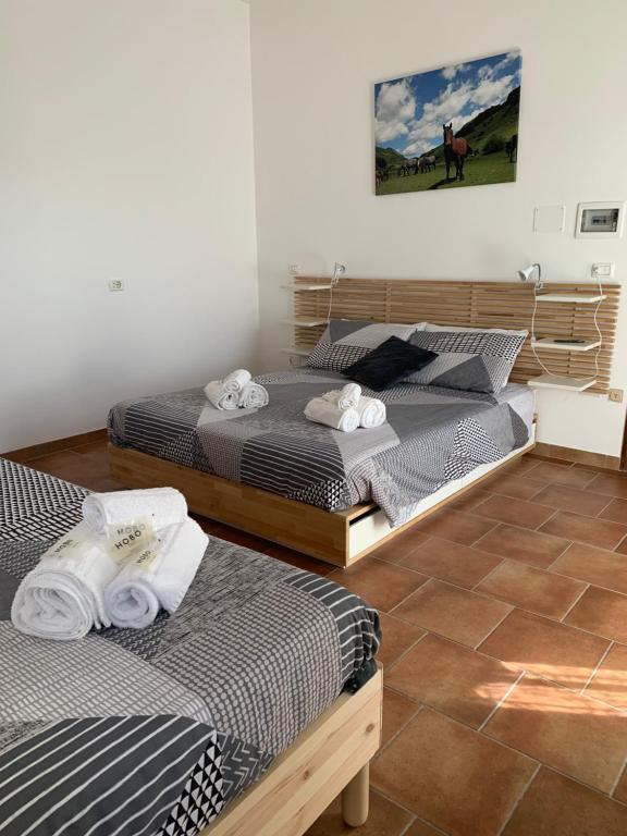 2 łóżka pojedyncze w pokoju z podłogą wyłożoną kafelkami w obiekcie Colle Veralli w mieście Foce