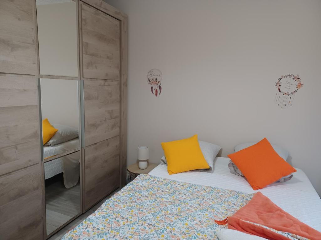 a bedroom with a bed and a mirror at APPARTEMENT, LA ROUTE DES GRANDES ALPES , 8 couchages, GARAGE pour motards, cyclistes, POSSIBILITÉ de studios supplémentaires, si plus de 8 personnes in Fourneaux