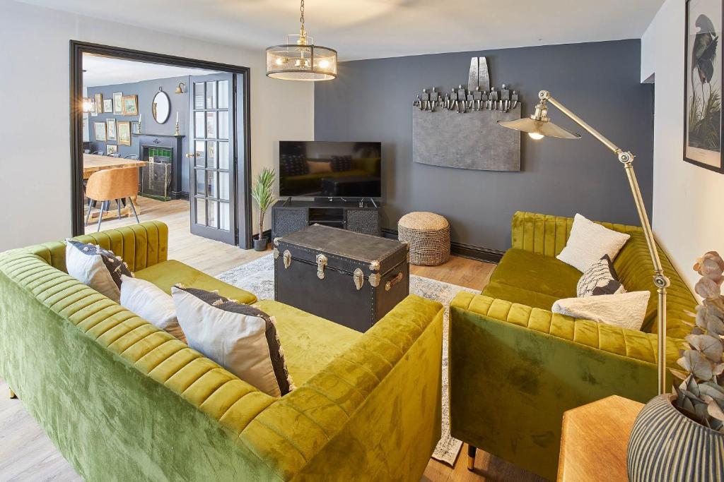 a living room with two yellow couches and a tv at Host & Stay - The Old Brewery in Richmond