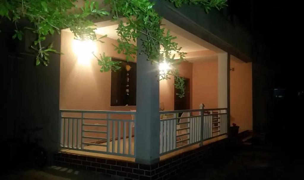 einen Balkon eines Hauses mit einer Säule in der Nacht in der Unterkunft Nice House next to a beautiful park in Tirana