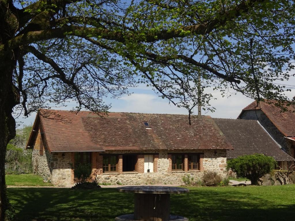 stary kamienny dom z brązowym dachem w obiekcie Maison de campagne en Limousin w mieście Dury