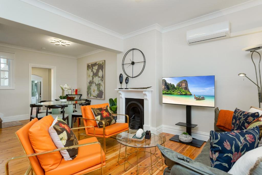 シドニーにあるBeautiful 2-Bed Terrace House with Outdoor Areasのリビングルーム(オレンジの椅子、暖炉付)