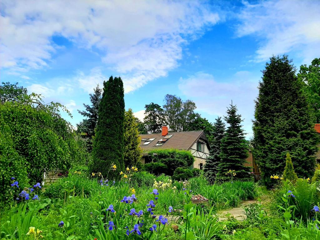 una casa con giardino fiorito e alberi di Champêtre Park View Apartments a Riga