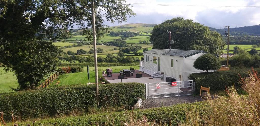 a tiny house in the middle of a garden at Countryside Caravan Accommodation - Abergele in Abergele
