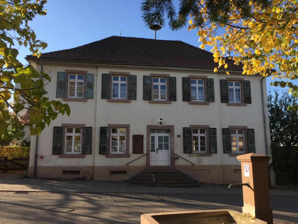 a white building with windows and stairs in front at Altes Schulhaus Mutschelbach in Karlsbad